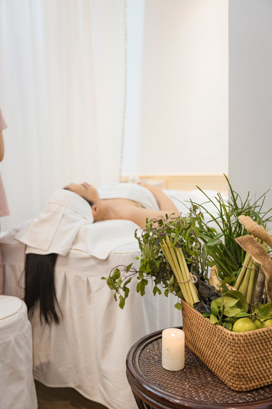 a woman lying on bed near basket of vegetables