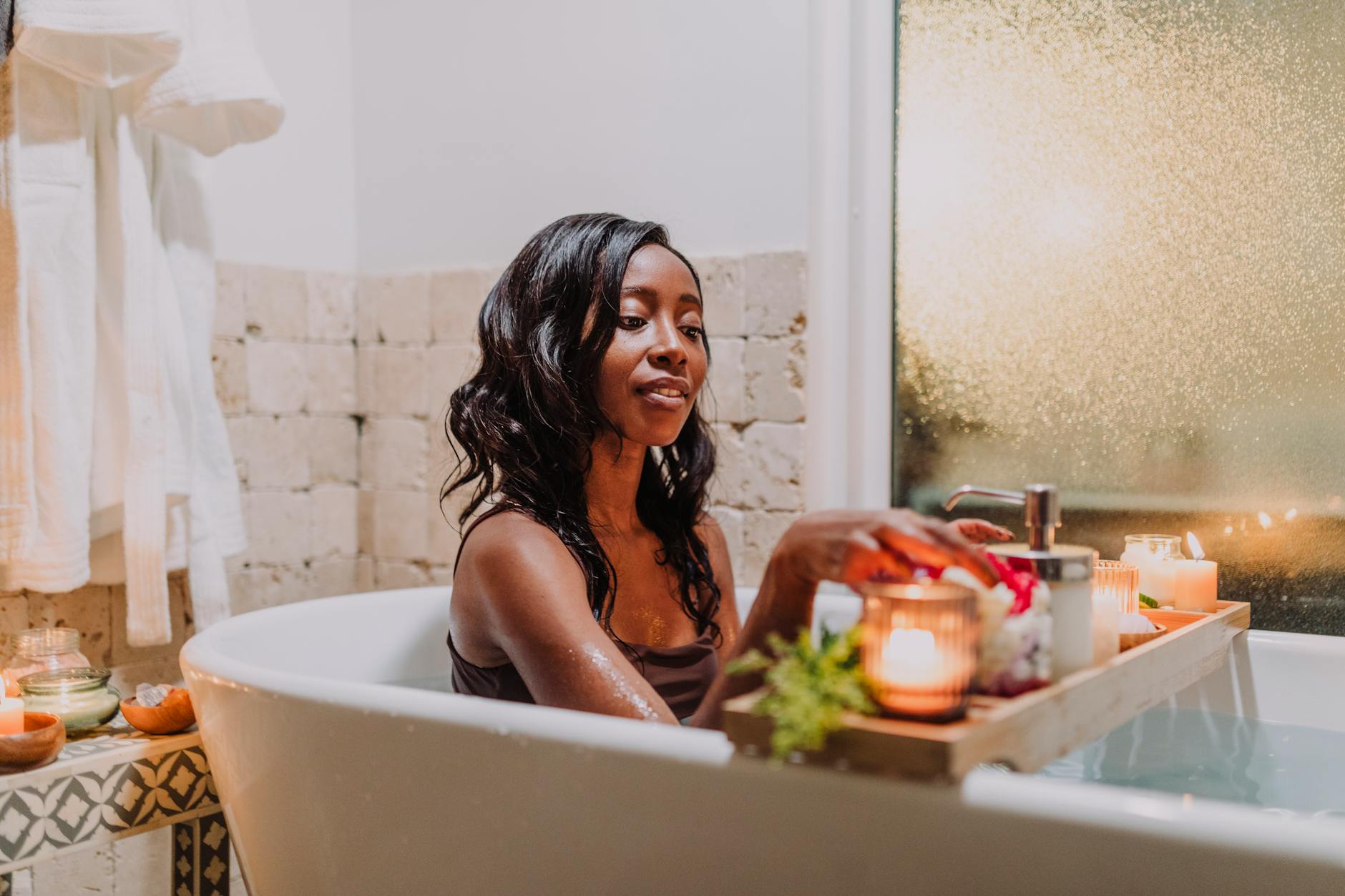 a woman in bathtub with a tray of candlelights